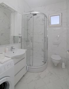 a white bathroom with a shower and a toilet at Vista Apartments in Cavtat +38 photos
