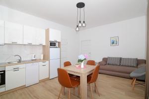 a kitchen and living room with a table and chairs at Vista Apartments in Cavtat