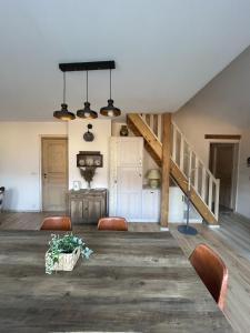 ein Zimmer mit einem Tisch, Stühlen und einer Treppe in der Unterkunft la maison du haut de Freydon Ambiance Scandinave in Allevard