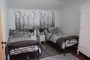two beds in a room with trees on the wall at la maison du haut de Freydon Ambiance Scandinave in Allevard