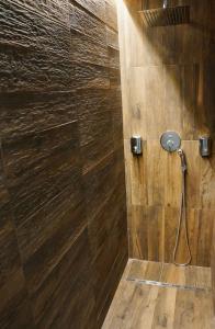 a bathroom with a shower with a wooden wall at Kiwi in Latina