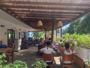 ACAMPALE - Camping Costa Brava - Calella de Palafrugell في كاليلا دو بالافروجيل: مجموعة من الناس يجلسون على الطاولات في المطعم