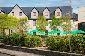 a group of green umbrellas in front of a building at Great National Hotel Ballina in Ballina