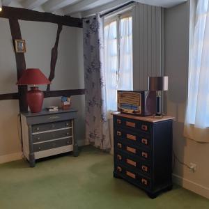 a room with a dresser and a lamp and a window at LA GAUDINIERE in Lyons-la-Forêt
