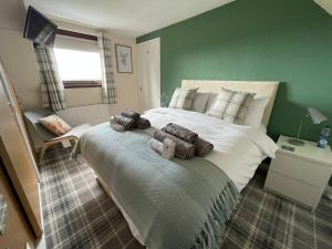 a bedroom with a large bed with two stuffed animals on it at Craggan in Dornoch