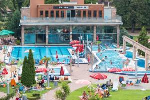 una piscina en un complejo con gente dentro en Holiday Beach Budapest Wellness Hotel with Sauna Park, en Budapest