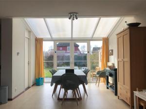 a dining room with a table and a large window at Maxime 209 - Kustpark Village Scaldia in Hoofdplaat