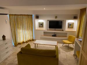 a living room with a couch and a tv at Le Relais de Campagne in Tréjouls