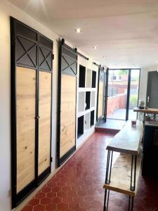 a room with wooden doors and a red tile floor at Loft atypique 192m2, terrasse, aux portes de Lille in Roubaix