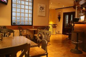 un ristorante con sedie, tavoli e una finestra di Apartamento Los Arcos a Llanes