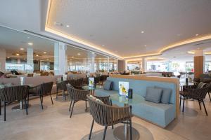 a restaurant with tables and chairs and a bar at Hipotels La Geria in Puerto del Carmen