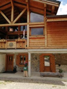 duży drewniany budynek z drewnianymi drzwiami i oknami w obiekcie Chalet Cathy et Michel w mieście Seytroux