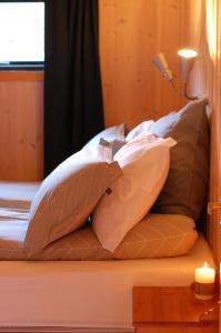 a bed with several pillows on it with a lamp at Reinunga Eco-hytta in Myrdal