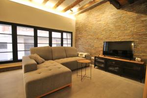 a living room with a couch and a flat screen tv at Fabrika Loft Serrallo in Tarragona