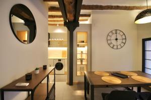 a dining room with a table and a clock on the wall at Fabrika Loft Serrallo in Tarragona