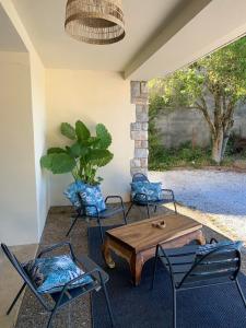 a patio with a table and chairs and a plant at Suite à la Villa Cattus in Bram