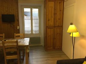 a dining room with a table and a lamp and a window at appartement à la montagne in Eaux-Bonnes