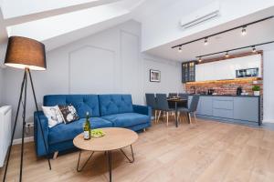 a living room with a blue couch and a table at Saint Florian's Suites - Old Town Luxury Apartments - by Upstairs in Kraków
