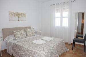 een slaapkamer met een bed met twee handdoeken erop bij La casita de Fran in Chiclana de la Frontera