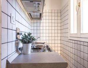 uma cozinha com fogão e uma planta no balcão em Barbieri23 Design by Wonderful Italy em Bolonha