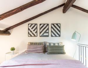 um quarto com uma cama com almofadas listradas em Barbieri23 Design by Wonderful Italy em Bolonha