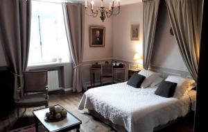 a bedroom with a bed and a table and a window at Manoir de la Baronnie in Saint Malo