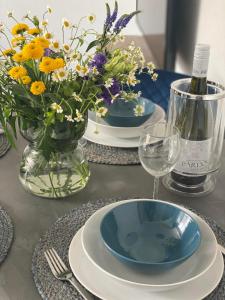 a table with two plates and a vase of flowers at Apartment Gradus in Dunajská Streda