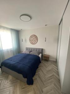 a bedroom with a large bed with a blue blanket at Apartment Gradus in Dunajská Streda