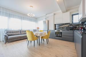 uma cozinha e sala de jantar com mesa e cadeiras amarelas em Alexander Flat em Oradea