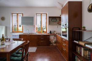 eine Küche mit Holzschränken, einem Tisch und einem Esszimmer in der Unterkunft NIDO DEL CODIROSSO in Ripe