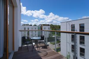 een balkon met een tafel en stoelen in een gebouw bij INA Rent - Nadmorski Dwór in Gdańsk