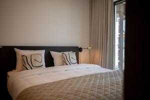 sypialnia z dużym łóżkiem i oknem w obiekcie Rots in de Branding Luxurious 2 bedroom apartment in the dunes with sea sight w mieście Cadzand