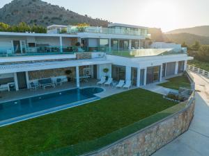 a large white house with a swimming pool at Villa Akrotiri in vlicha