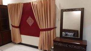 a room with a mirror and a curtain at Hotel Royal Defence in Lahore