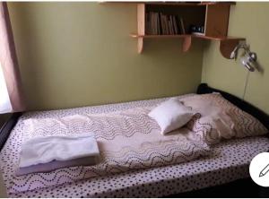 uma cama com dois cobertores e almofadas em Hunyadi utcai garzon em Kaposvár