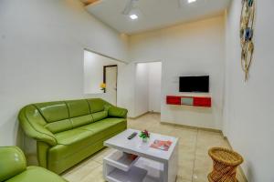 a living room with a green couch and a table at IT'S HOME in Aurangabad