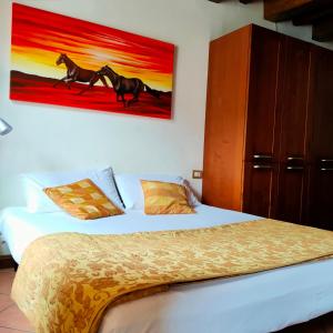 - une chambre avec un lit orné d'une peinture de chevaux sur le mur dans l'établissement Monolocale sul lago, à Lecco