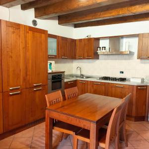 - une cuisine avec une table en bois et des placards en bois dans l'établissement Monolocale sul lago, à Lecco