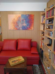 uma sala de estar com um sofá vermelho numa biblioteca em Ferienwohnung im Zentrum von Sooden em Bad Sooden-Allendorf