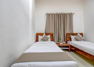 a bedroom with two beds and a window at IT'S HOME in Aurangabad