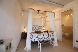 um quarto com uma cama em preto e branco com cortinas em Hotel Noto Marina e Spa em Noto Marina