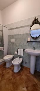 ein Badezimmer mit einem Waschbecken, einem WC und einem Spiegel in der Unterkunft Controvento in Porto Cesareo