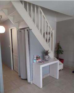 uma escada com uma mesa branca num quarto em La maison de lavande em Laon