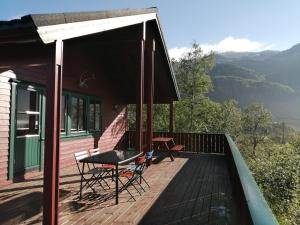 a house with a deck with a table and chairs at Reinunga Eco-hytta in Myrdal