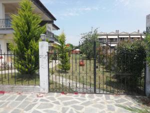 a gate in a yard with trees and a building at My Erofili in Keramotí