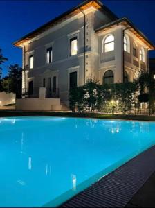 una casa grande con piscina frente a ella en Livia Valeria Palace, en Roma