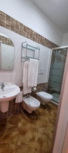 ein Badezimmer mit zwei Waschbecken, einem WC und einem Spiegel in der Unterkunft Controvento in Porto Cesareo
