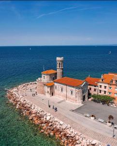 a building with a clock tower next to the ocean at Vila Piranesi Apartments - Parking included in Piran