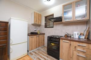 a kitchen with a white refrigerator and a black stove at Weekendaya in Kladovo