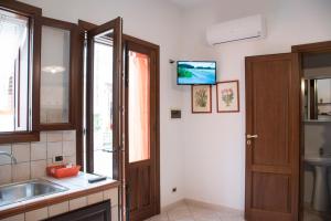 a kitchen with a sink and a door with a television at La casa di Cecè al centro di San Vito Lo Capo in San Vito lo Capo +12 photos